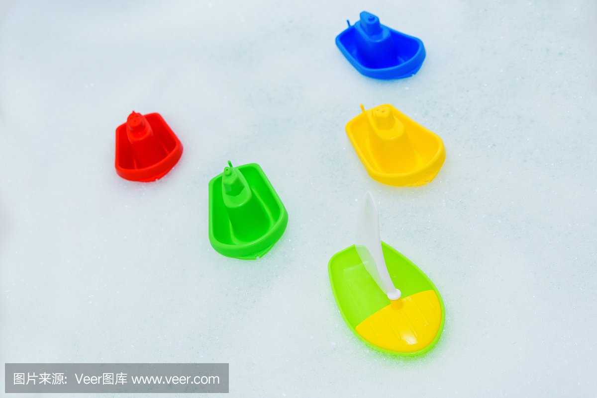 泡沫浴上的五颜六色的塑料玩具船。